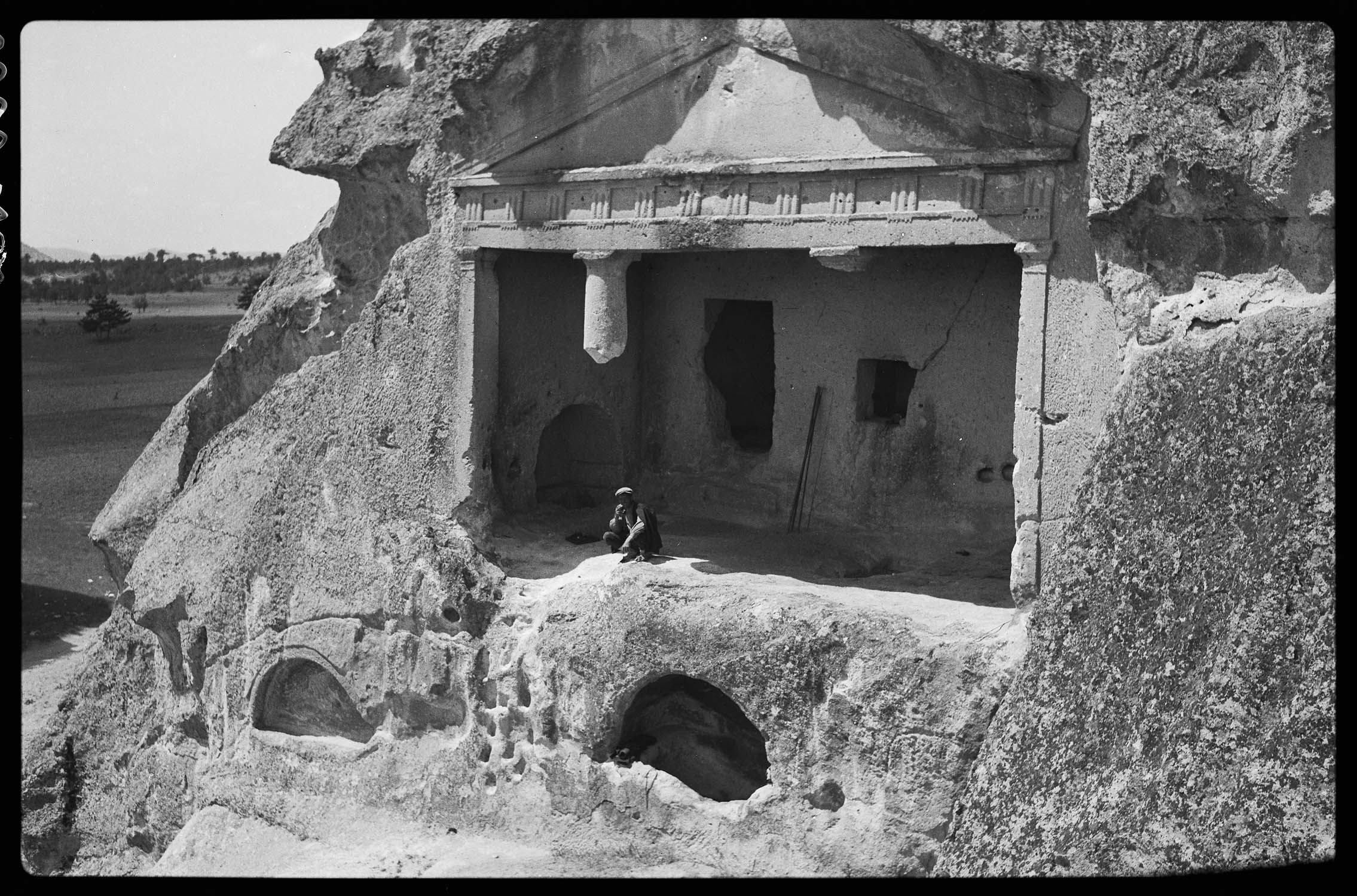 Vue du monument, avec un ouvrier sur le seuil (voir "Phrygie. Exploration archéologique…", tome IV : "La Cité de Midas. Architecture", par A. Gabriel, Paris, E. de Boccard, 1965, pl. 40-41)